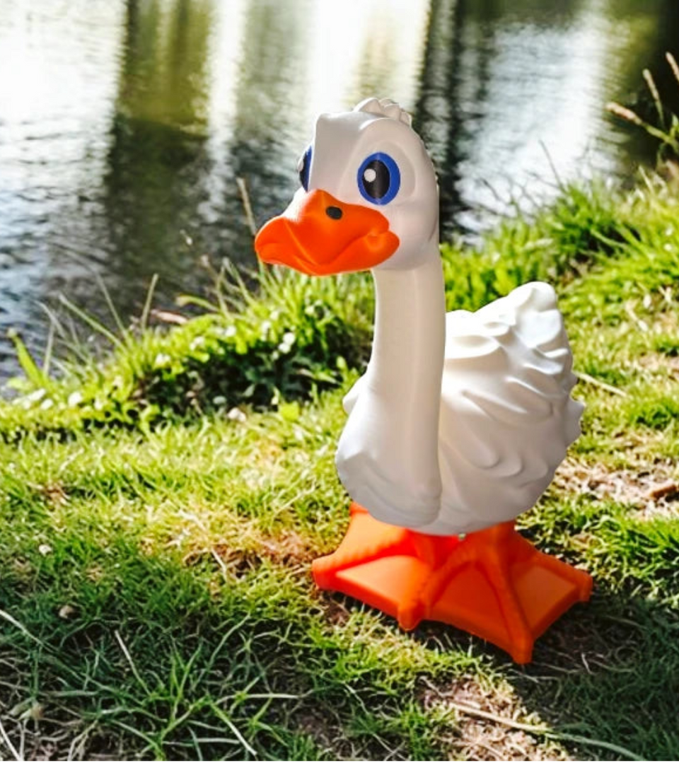  Toy goose on grass with water in the background