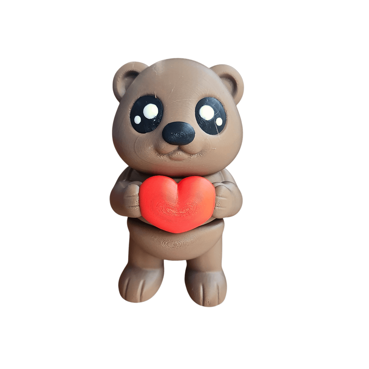 Adorable brown teddy bear holding a red heart