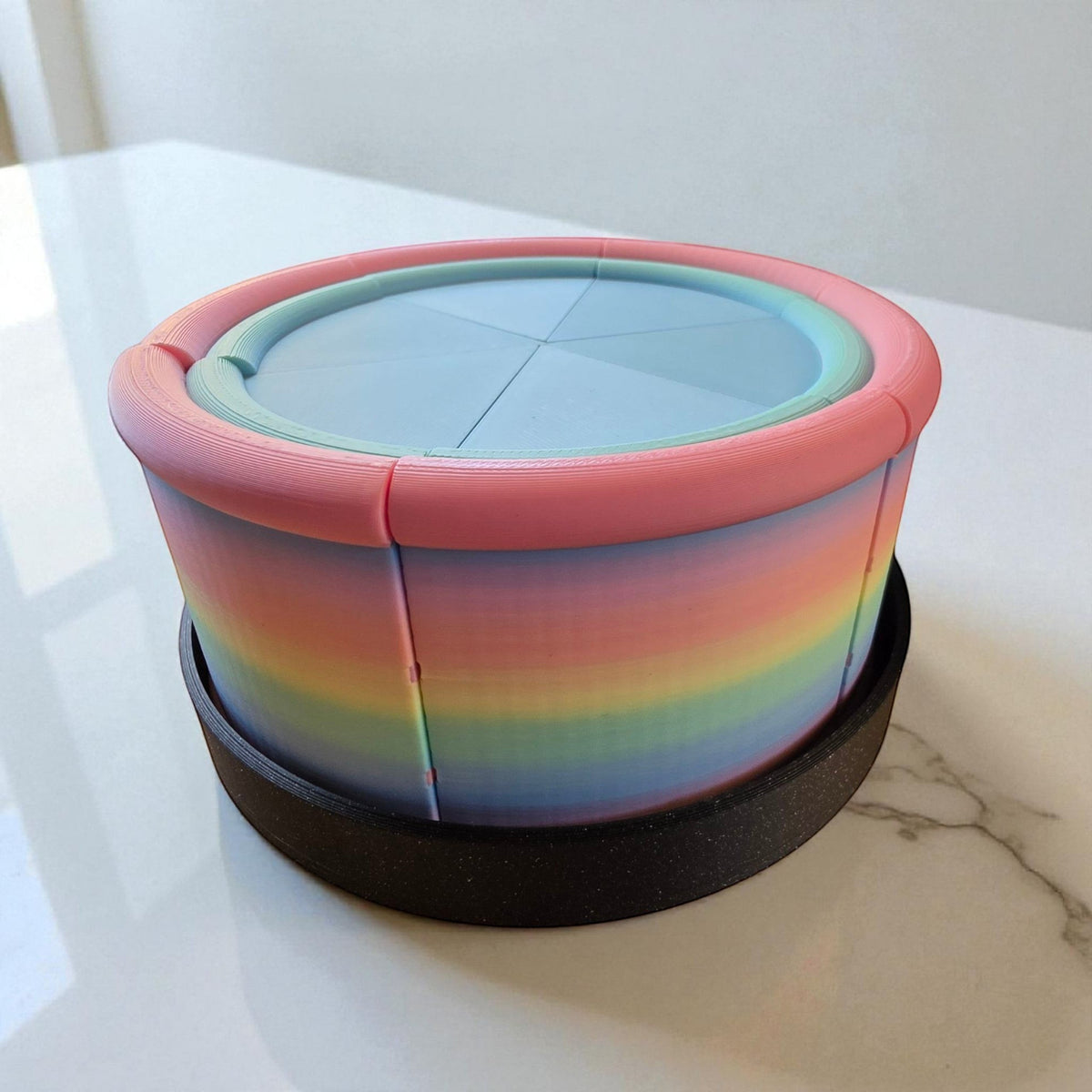 Fragrant Moon Designs rainbow gradient 3D printed pretend cake with pastel pink frosting and blue top.